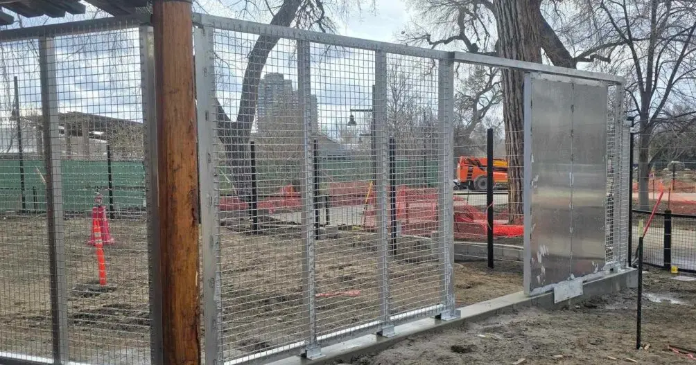 Solid steel keeper door with heavy-duty hinges set into galvanized framed welded mesh, fabricated by TCB Metal Works